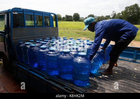 1001 Brunnen Wasser. Mitarbeiter laden Korbflaschen auf einen Lastwagen. Kambodscha. Stockfoto