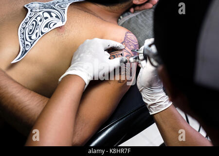 7/8 Hände tattoo Artist tattooing Schulter des Menschen Stockfoto