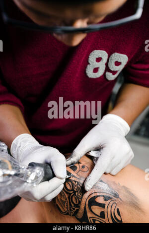 Hohe Betrachtungswinkel von Tattoo artist tattooing Schulter des Menschen Stockfoto