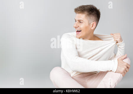 Hübscher junger Mann in einem weißen Pullover Stockfoto