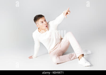 Hübscher junger Mann in einem weißen Pullover Stockfoto