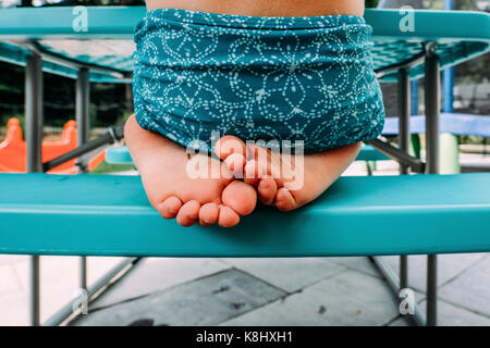 Low-Feld der Mädchen sitzt auf der Bank im Park Stockfoto