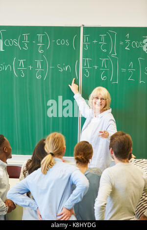 Dozent lehrt Mathematik an Studenten und Formel lösen Stockfoto