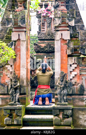 Indonesien. Bali. Ubud. Balinesische Frau in einem Tempel beten Stockfoto