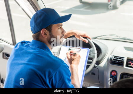 Delivery man Schreiben über die Zwischenablage Stockfoto