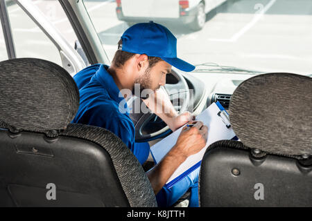 Delivery man Schreiben über die Zwischenablage Stockfoto