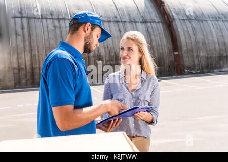 Frau Unterzeichnung Lieferung Dokument Stockfoto