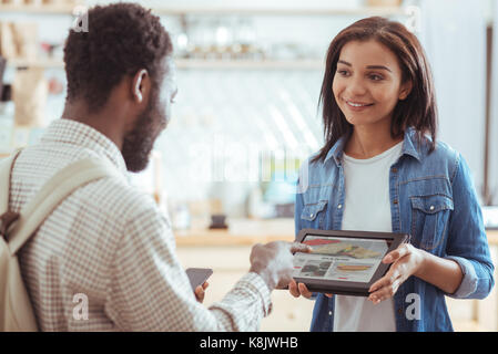 Angenehme Menschen wählen Sie Gerichte von der Speisekarte, die auf Notebook Stockfoto