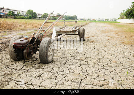 Schäden, die alten Traktor und Anhänger Anschlag auf Reisfeld warten Frühling auf Wüste Land, weil Dürre Katastrophe im Hinterland von Thailand