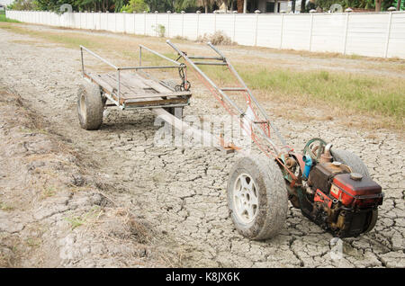 Schäden, die alten Traktor und Anhänger Anschlag auf Reisfeld warten Frühling auf Wüste Land, weil Dürre Katastrophe im Hinterland von Thailand