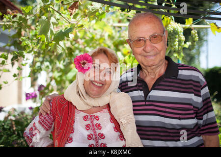 Elder rumänischen Paar, die Frau, die in der rumänischen traditionelle Tracht gekleidet. Stockfoto