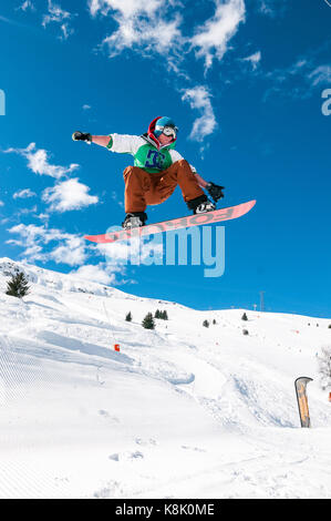 Snowboarder springen Schnee Rampe in die Luft, 3 Täler Skigebiet Meribel, Frankreich Stockfoto