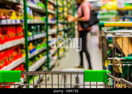 Blick von Einkaufswagen in abstrakte verschwommen Supermarkt gang Hintergrund. Stockfoto