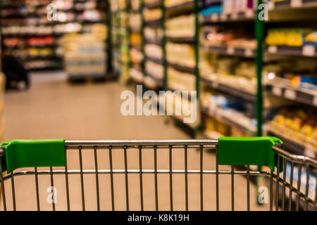Blick von Einkaufswagen in abstrakte verschwommen Supermarkt gang Hintergrund. Stockfoto
