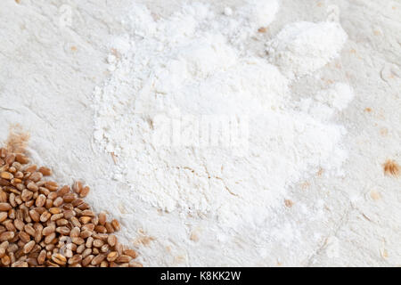 Weißes Mehl und Weizen Körner in einem Haufen Lügen auf weißem Weizen pita Brot. foto Close-up auf der Oberseite Stockfoto