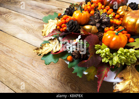 Fallen oder Thanksgiving Anordnung mit Kürbissen und Blätter im Herbst auf der rechten Seite des alten Holztisch. Urlaub Hintergrund mit Beeren und Kegel wrea Stockfoto