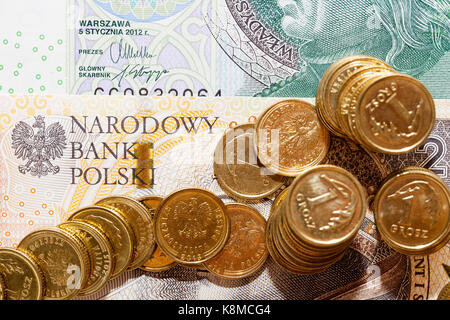 Mehrere polnische Münzen auf Papier Währung Anzeichen von Polen liegen. In der Nähe fotografiert. Stockfoto