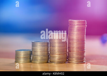 Einsparungen, Erhöhung der Spalten von Goldmünzen, Stapel von Goldmünzen als Grafik auf Holztisch, Business Banking Idee. vintage Ton. Stockfoto