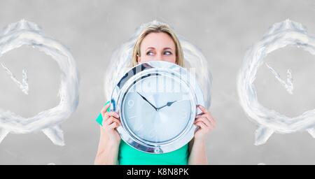 Digital composite der Frau mit einer Uhr gegen Hintergrund mit Uhren Stockfoto