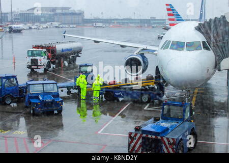 New York, USA - 30. September 2016: Airport Ground Crew handling Gepäck an einem regnerischen Tag in LaGuardia Airport Vorbereitung für den Flug. Stockfoto