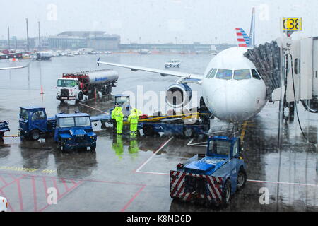 New York, USA - 30. September 2016: Airport Ground Crew handling Gepäck an einem regnerischen Tag in LaGuardia Airport Vorbereitung für den Flug. Stockfoto