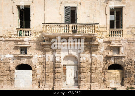 Ein Bröckelnden alten Gebäude aus Stein mit einem maltesischen Balkon in Malta Stockfoto