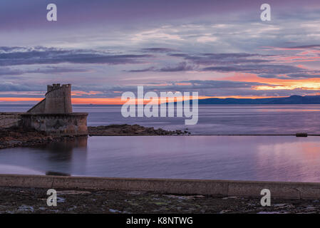 Ein schöner Sonnenuntergang über Ardrossan und Arran mit dem Firey Sonne reflektiert das Wasser in der Bucht zwischen Saltcoats und Ardrtossan. Stockfoto