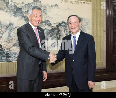 (170920) - BEIJING, Sept. 20, 2017 (Xinhua) - Wang Qishan (R), Leiter der Kommunistischen Partei Chinas zentrale Kommission für Disziplin Inspektion, trifft sich mit Singapurs Premierminister Lee Hsien Loong in Peking, der Hauptstadt von China, Sept. 20, 2017. (Xinhua/Li Tao) (lfj) Stockfoto