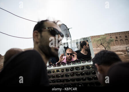 Erbil, Irak. 20 Sep, 2017. Kurdische Männer shop für Sonnenbrillen backdropped durch die Zitadelle in Erbil, Irak, 20. September 2017. Erbil ist eine der Städte, die in einem umstrittenen Unabhängigkeit Abstimmung teilnehmenden am 25. September. Einen unabhängigen kurdischen Staat ist stark von der Zentralregierung in Bagdad und der westlichen Großmächte wie die USA. Credit: Oliver Weiken/dpa/Alamy leben Nachrichten Stockfoto