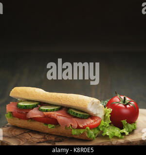 Sandwich mit Lachs und Gemüse auf Holztisch Stockfoto