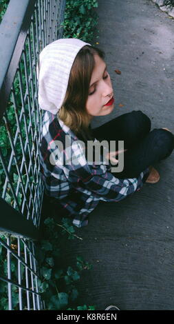 Junge Frau in der Natur sitzen Stockfoto