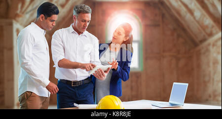 Architekten diskutieren über Tablet Computer gegen Zimmer in Haus Baustelle Stockfoto