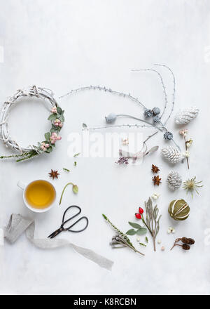 Weihnachten mit der Natur flatlay Versammlungen, Beeren, Blumen, Kranz, teetasse und Schere, Gewürze und getrocknete Limonen. Natürliches Licht, Ansicht von oben Stockfoto