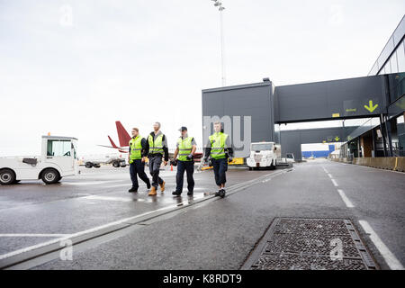 Die volle Länge der Arbeitnehmer zusammen zu Fuß auf Start- und Landebahn Stockfoto