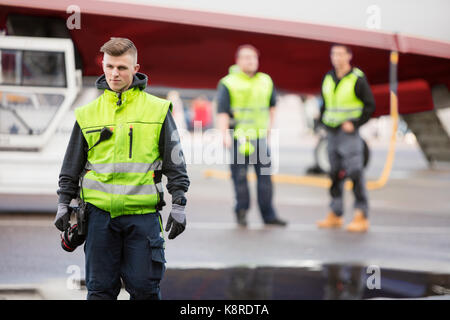 Zuversichtlich Boden Mitarbeiter stehen auf Landebahn Stockfoto