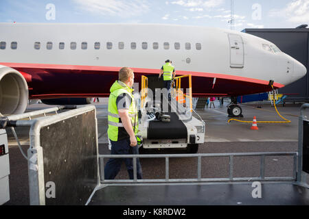 Mannschaft arbeiten bei Gepäck Förderband am Flugzeug Stockfoto