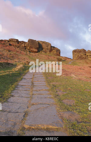 Blick auf Stein Weg, Bracken und Felsen auf Moorland Lebensraum, Kuh und Kalb Felsen, Ilkley Moor (SSSI), Rombalds Moor, Ilkley, Wharfedale, West Yorkshire, Stockfoto
