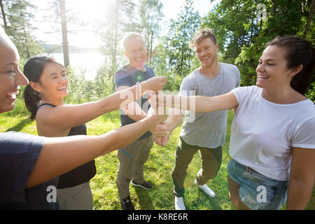 Mitarbeiter Stapeln Fäuste beim Stehen in Wald Stockfoto