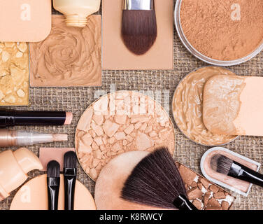 Make-up-Produkte die perfekte Teint zu erstellen. Stiftung, kompakt, Lose und Schimmern golden Pulver, gemahlen Bronzing Powder, Bürsten und Schwämme Stockfoto