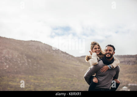 Hübscher junger Mann huckepack seine Freundin. Glückliches junges Paar das Leben zu genießen. Stockfoto