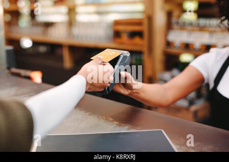 Kunden drahtlose oder kontaktlose Zahlung mit Kreditkarte. Store Arbeitnehmer akzeptieren Zahlung über NFC-Technologie. Stockfoto