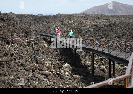 Gehweg über Lava Feld, Timanfaya Vulkan Interpretation und Besucher Zentrum, Lanzarote, Kanarische Inseln, Spanien Stockfoto