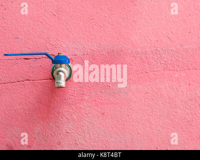 Alte blaue Wasserhahn auf dem roten Betonwand in der örtlichen Grundschule, Thailand. (Kopie) Stockfoto