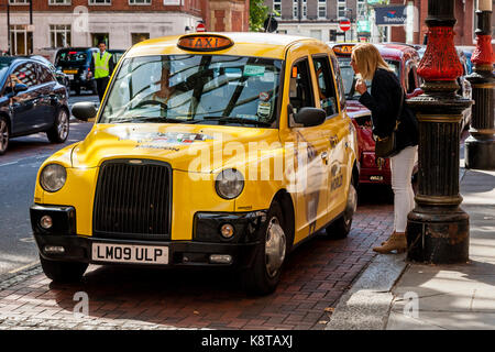 Eine Frau fragt einen Taxifahrer eine Frage, Bahnhof Marylebone, London, UK Stockfoto