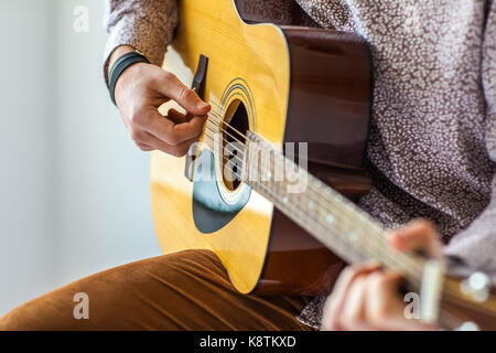 Des Menschen Hände spielen akustische Gitarre. Nahaufnahme Stockfoto