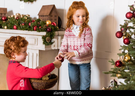 Geschwister schmücken Weihnachtsbaum Stockfoto