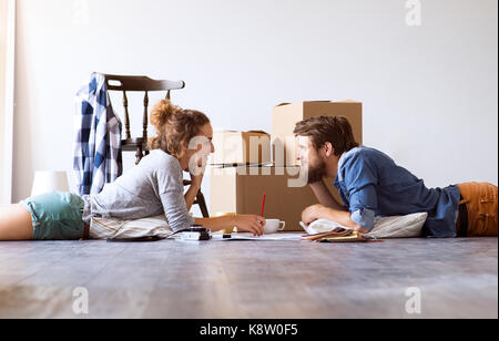 Junges Paar Umzug in neues Haus, auf dem Boden liegt. Stockfoto