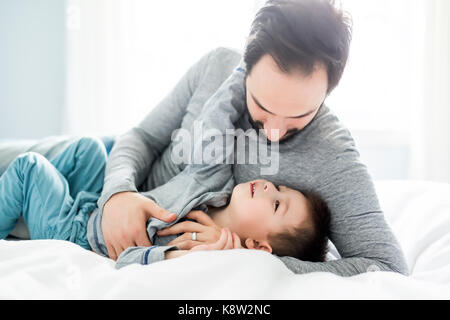 Vater und Sohn im Bett, glückliche Zeit auf dem Bett Stockfoto