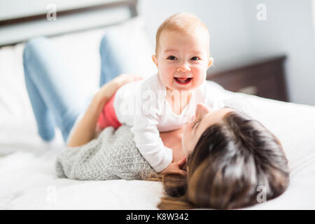 Mutter und Baby Kind auf einem weißen Bett. Stockfoto