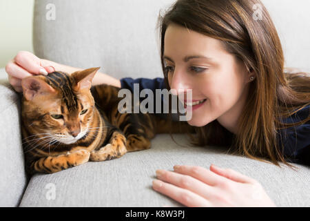 Katze und Frau im Wohnzimmer auf der Couch Stockfoto